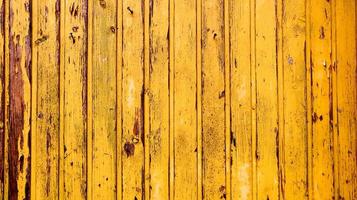 Viejo fondo de textura de madera amarilla. pared de madera pintada. fondo amarillo. cerca brillante hecha de tablas verticales. la textura de una tabla de madera se puede utilizar como fondo. un poco de pintura agrietada.