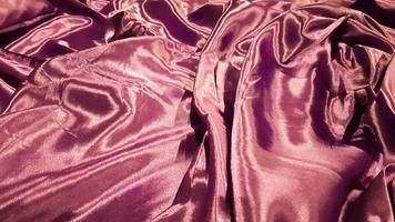 violet fabric close up background. Smooth elegant silk or satin texture can be used as background. Abstract drapery fabric, weave of fabric background photo