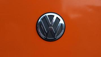 Ukraine, Kiev - March 29, 2020. Close-up of the logo on the orange body of a Volkswagen SUV. photo