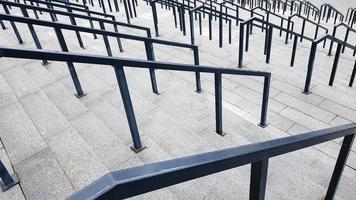 External multi-stage stone staircase. There are a lot of stairs and railings made of metal. Many steps in an urban environment, symbolic abstract background. photo