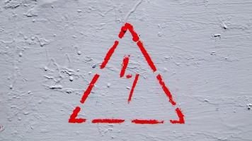Red electrical hazard sign with lightning in a triangle on a gray painted metal junction box. photo