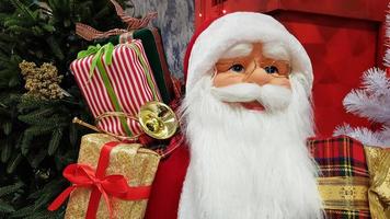 Photo portrait of a happy toy doll Santa Claus with a bag of gifts symbolizes the coming of Christmas and New Year. Festive mood, holiday concept.