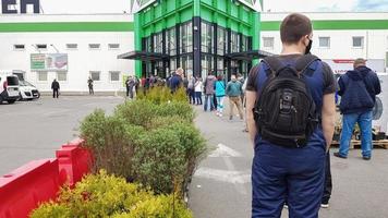 Ukraine, Kiev - May 07, 2020. Many people line up near a construction supermarket or grocery store, waiting in line to enter because of the coronavirus pandemic safety directive. Crowd restriction photo