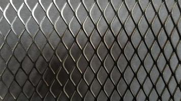 Metal mesh seamless pattern. Black metal mesh texture on a black background. Bulletin board for text and message design. Rhombus shape photo