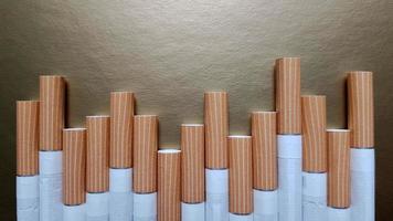 imagen de varios cigarrillos comerciales. Montón de cigarrillos sobre un fondo dorado o concepto de campaña antitabaco, tabaco foto