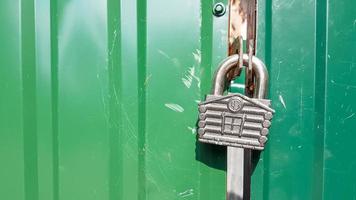 metal door with lock, texture and background. Background texture of an iron padlock on a rusty metal gate. photo