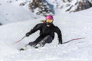 Joven mujer rubia esquiando en un día soleado foto