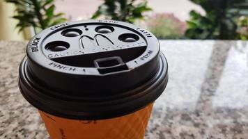 Close-up of McDonald's fast food restaurant logo on a black paper cup lid with hot McCafe coffee. Breakfast, coffee time. Ukraine, Kiev - September 30, 2020. photo