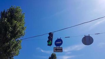 Traffic light and signs on the street close up with a burning green light photo