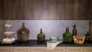 Large glass vases, a basket with apples and plates in the interior of a modern kitchen. The combination of wood and concrete in the design. Modern style dining kitchen photo