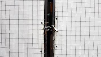 Closed padlock on a hangar from a grid and a white banner photo