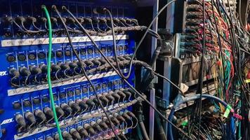 una placa con muchos enchufes y cables conectados. instalación de sonido. equipo de ingeniero de sonido. foto