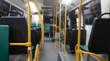 un autobús vacío está equipado con pasamanos para sujetarlo en el interior. moderno transporte público de pasajeros suburbano y urbano terrestre en la ciudad. asientos de pasajeros. foto