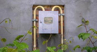 Natural gas meter with yellow pipes measuring gas consumption. An external gas meter in a private house for the distribution of domestic gas. photo