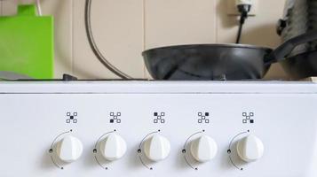 Gas stove. Not a new white gas stove in the interior of the kitchen. Before cleaning, dirty regulators on a white home gas stove. photo