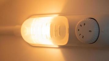 Orange light inside the refrigerator close-up. A lamp that turns on when the door is open to improve vision. Household appliances concept, changing the lamp in the freezer. photo