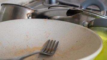 The kitchen utensils in the wash basin need to be washed. A pile of dirty dishes in the kitchen sink. Kitchen utensils need washing. Homework concept. photo