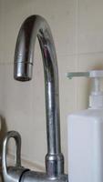 Old tall mixer in the kitchen with a dispenser of liquid soap for washing dishes, close-up. Vertical photography. photo