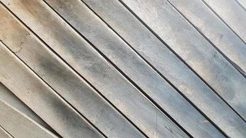 Gray wooden background with diagonal lines. Board background with copy space. Wooden old boards with cracked gray paint on the diagonal. Selective focus. Textured wooden background. photo