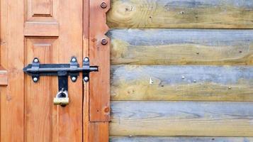 Old wooden door with a black metal bolt. Close up view of a lock and latch on a wooden door. Rustic wooden metal door latch. This sliding lock can be used on awnings, on desktops or on fences. photo