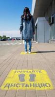 Ukraine, Kiev - April 23, 2020. Yellow pavement with warning. Keep your distance on the sidewalk. The text is in Ukrainian. Concept of maintaining social distance, quarantine or isolation. photo