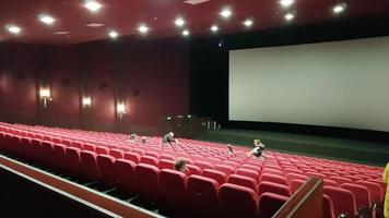 Ucrania, Kiev - 2 de junio de 2020. Fondo de asiento rojo en una sala de cine sin gente. asientos teatrales y una pantalla blanca foto