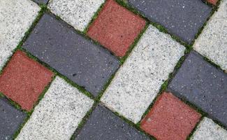 Colored background and texture of new paving slabs. The texture of the paved tiles is red and gray. Cement brick squared stone floor background. Concrete paving slabs.