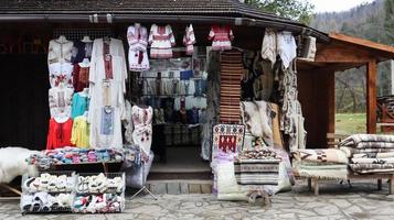 mercado de recuerdos en Yaremche con ropa tradicional de los Cárpatos, hierbas y herramientas de madera. textiles ucranianos, calcetines de punto, chalecos, sombreros. ucrania, yaremche - 20 de noviembre de 2019 foto