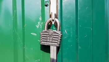 metal door with lock, texture and background. Background texture of an iron padlock on a rusty metal gate. photo