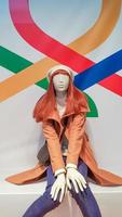 one woman mannequin in luxurious winter or autumn clothes in a shop window. A red-haired female mannequin demonstrates a casual collection of clothing. Brown coat. photo