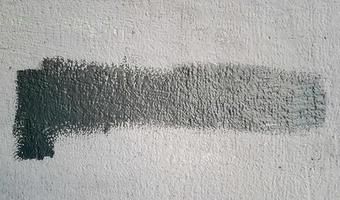 Gray concrete wall. Large coarse strokes of paint on the surface of the house. Close-up. Classic background. Copy space. Place for text. photo