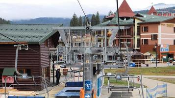 Ukraine, Bukovel - November 20, 2019. Autumn view of the ski resort with a chairlift against the background of autumn mountain slopes and the infrastructure under construction of a winter ski resort. photo