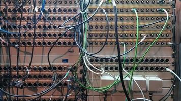 A board with many sockets and connected wires. Sound installation. Sound engineer equipment. photo