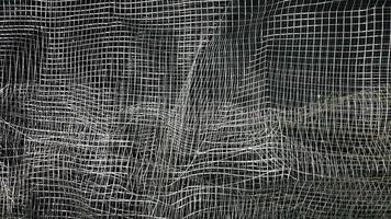 Crumpled mesh. Abstract background. Metal mesh with shadow on a black background. The surface of a large roll is damaged by wire mesh. photo