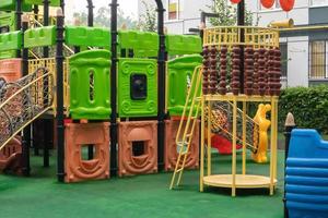 The courtyard of a high-rise building with a modern large playground made of wood and plastic on a rainy summer day without people. Ukraine, Kiev - August 19, 2021. photo