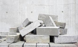 A pile of cement type bricks. Solid brick is used for construction. Lots of loose concrete bricks at the construction site. photo