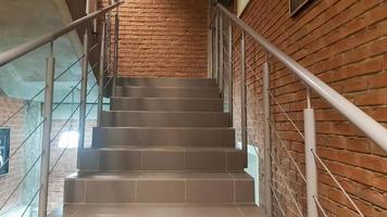 Red brick building with a modern staircase in a loft style with metal railing. Stairs adorn the building. Modern stairwell. Steel railing. Staircase in perspective. photo