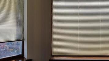 Las persianas están unidas a la ventana para proteger del calor y la luz solar en el interior. las persianas enrollables de la casa captan la luz del sol. foto