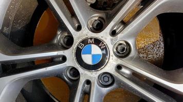 Ukraine, Kiev - August 28,2019. Original BMW alloy wheel dirty and scratched with tires on a car close-up photo