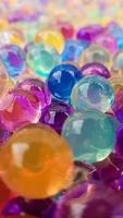 Lots of different colored hydrogel balls. Set of multicolored orbis. Crystal water beads for games. Helium balloons. Can be used as a background. Polymer gel Silica gel. photo