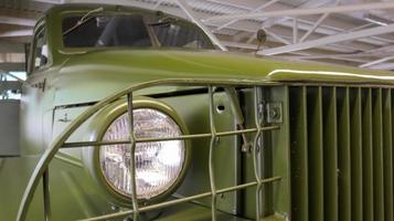 Close-up is the round headlight of a khaki military truck. The three-axle truck was produced from 1941 to 1945. Increased cross-country ability and carrying capacity. Ukraine, Kiev - June 09, 2021. photo