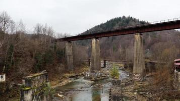 vista del puente ferroviario sobre el río Prut. una pequeña ciudad o pueblo de Yaremche entre los Cárpatos en una tarde de otoño. ucrania, yaremcha - 20 de noviembre de 2019. foto