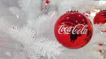 Coca Cola Christmas red ball decoration. Marketing from the world leader in carbonated drinks. Coca Cola advertisement Christmas tree decoration. Ukraine, Kiev - January 05, 2021. photo