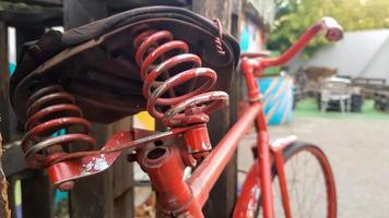 Retro vintage red bike close up. An old charming concept of a classic abandoned bike. photo