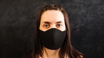 portrait of a woman, young woman wearing a hygienic facial medical mask to prevent infection, illness or flu, and 2019 nKoV. Grey background. Protection against diseases, coronaviruses. photo