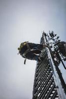 Telecom Worker Climbing Antenna Tower photo