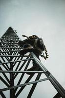 Telecom Worker Climbing Antenna Tower photo