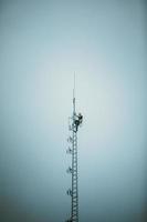 trabajador de telecomunicaciones subiendo torre de antena foto