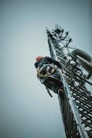 trabajador de telecomunicaciones subiendo torre de antena foto