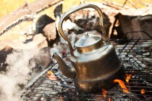 Kettle with water heated on the fire photo